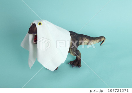 a plastic t-rex dinosaur figurine disguised as a ghost with a sheet and false eyes a plastic t-rex dinosaur figurine disguised as a ghost with a sheet and false eyes 107721371