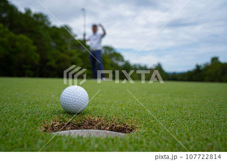 Blurred golfer playing golf in the evening golf course, on sun set evening time. Blurred golfer playing golf in the evening golf course, on sun set evening time. 107722814