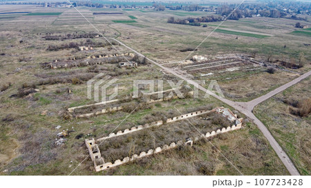 Destroyed agricultural buildings, aerial view. Abandoned livestock farm. 107723428