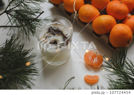 Candle, tangerines and pine. Christmas background with fir tree branches and tangerines merry christmas and happy new year. 107724454