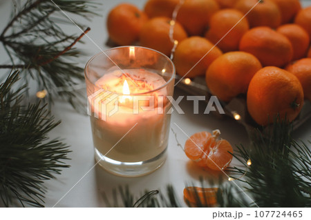 Candle, tangerines and pine. Christmas background with fir tree branches and tangerines merry christmas and happy new year. 107724465