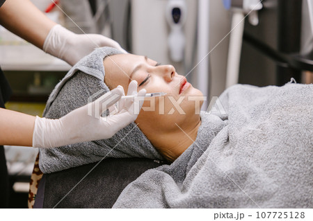 woman needle injection filler for face lifting remove wrinkles in facial spa skin care clinic 107725128