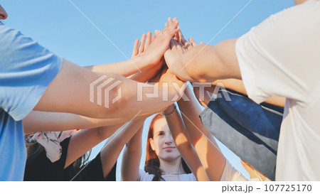 Friends join hands in the center standing in a circle. Friends join hands in the center standing in a circle. 107725170