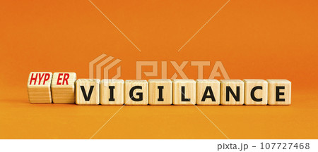 Vigilance or hypervigilance symbol. Concept words Vigilance Hypervigilance on wooden blocks. Beautiful orange table orange background. Psychology vigilance hypervigilance concept. Copy space. 107727468