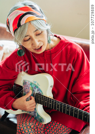 ギターを手に趣味を楽しむシニア女性 ギターを手に趣味を楽しむシニア女性 107729889