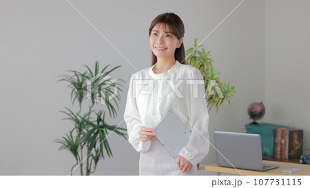 タブレットを持ちオフィスを歩くビジネスウーマン1 107731115