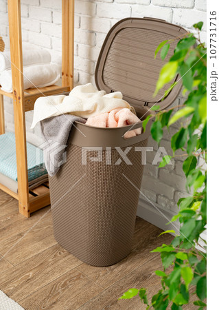 Pile of clothes in plastic laundry basket in the bathroom Pile of clothes in plastic laundry basket in the bathroom 107731716