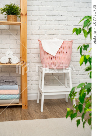 Pink plastic laundry basket in a bathroom 107731738