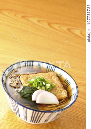 油揚げ、かまぼこ、ワカメ、葱が乗ったきつね蕎麦 油揚げ、かまぼこ、ワカメ、葱が乗ったきつね蕎麦 107731788