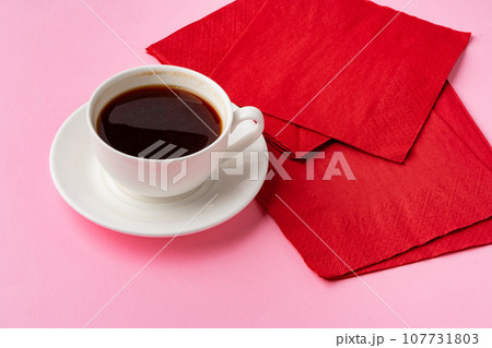 Coffee cup with paper napkins on pink background 107731803