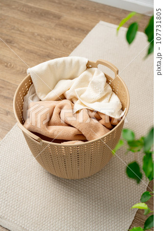 Pile of clothes in plastic laundry basket in the bathroom Pile of clothes in plastic laundry basket in the bathroom 107731805