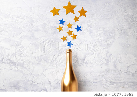 Champagne bottle with confetti flat lay top view Champagne bottle with confetti flat lay top view 107731965
