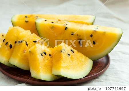 Yellow watermelon sliced on wooden background Yellow watermelon sliced on wooden background 107731967