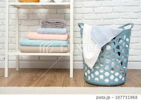 Blue plastic laundry basket in a bathroom 107731968