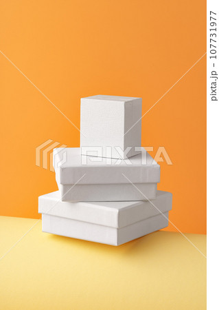 Three closed white jewelry boxes on yellow background 107731977