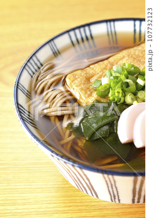 油揚げ、かまぼこ、ワカメ、葱が乗ったきつね蕎麦 107732123