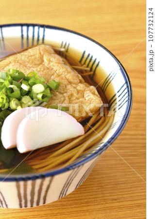 油揚げ、かまぼこ、ワカメ、葱が乗ったきつね蕎麦 107732124