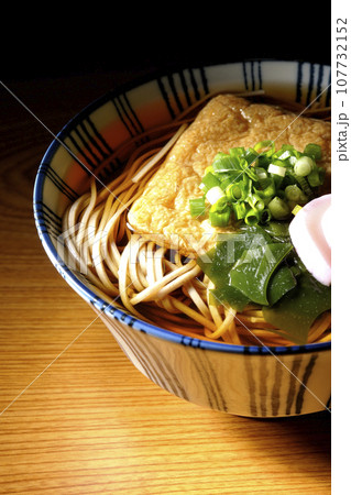 油揚げ、かまぼこ、ワカメ、葱が乗ったきつね蕎麦 油揚げ、かまぼこ、ワカメ、葱が乗ったきつね蕎麦 107732152
