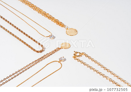 Set of gold chains with pendant on white background 107732505