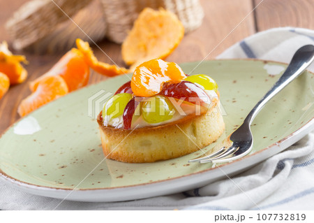 Tart with fruits topping on green plate 107732819