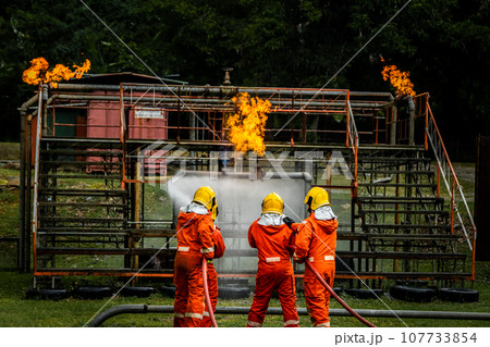 Firefighter Concept. Fireman using water and extinguisher to fighting with fire flame. 107733854