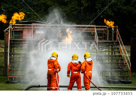 Firefighter Concept. Fireman using water and extinguisher to fighting with fire flame. Firefighter Concept. Fireman using water and extinguisher to fighting with fire flame. 107733855