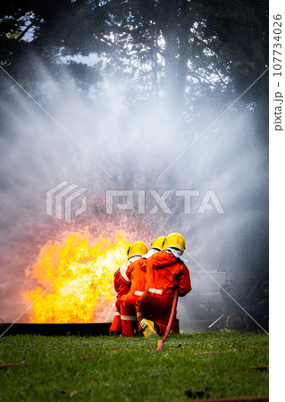 Firefighter Concept. Fireman using water and extinguisher to fighting with fire flame. Firefighter Concept. Fireman using water and extinguisher to fighting with fire flame. 107734026