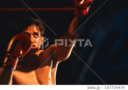 Asian and Caucasian Muay Thai boxers exchanging punch. Impetus 107734434
