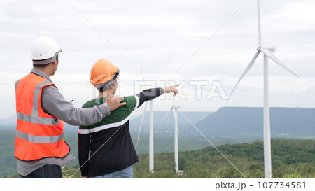 Progressive engineer with his son in the wind farm atop of the mountain. Progressive engineer with his son in the wind farm atop of the mountain. 107734581