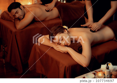 Hot stone massage at spa salon in luxury resort with warm candle light.Quiescent Hot stone massage at spa salon in luxury resort with warm candle light.Quiescent 107734697