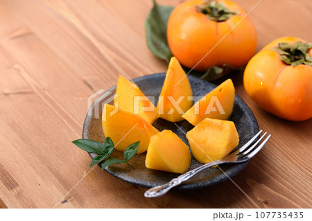 とっても甘い秋の味覚 柿 フルーツ （木目バック）柿の実 107735435