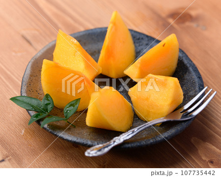 とっても甘い秋の味覚 柿 フルーツ (木目バック)柿の実 とっても甘い秋の味覚 柿 フルーツ (木目バック)柿の実 107735442