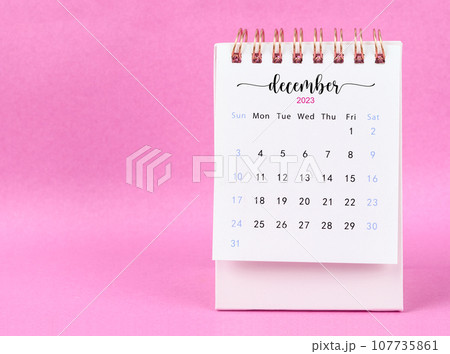 The December 2023 desk calendar for 2023 year on pink color background. 107735861