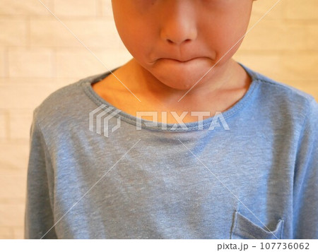 悔しくて唇をかみしめる男の子 107736062