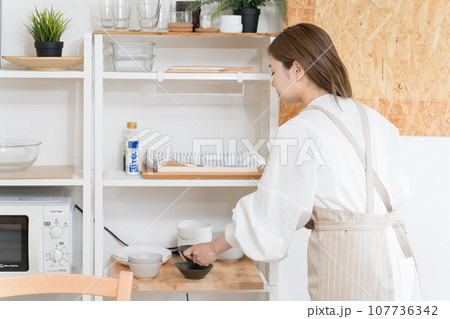キッチンで食器を片付ける若い女性　家事代行 107736342