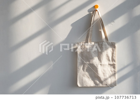 Textile shopping bag hanging from hook. 107736713