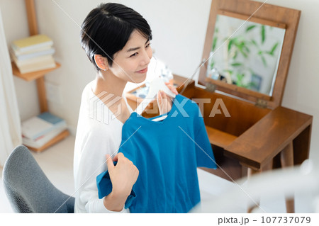 部屋で洋服選びをする女性 部屋で洋服選びをする女性 107737079
