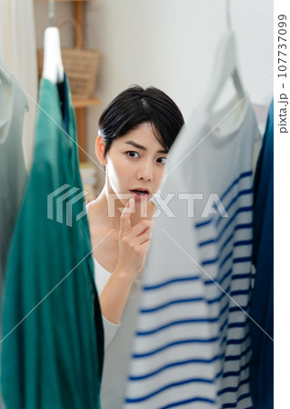 部屋で外出準備をする女性 107737099