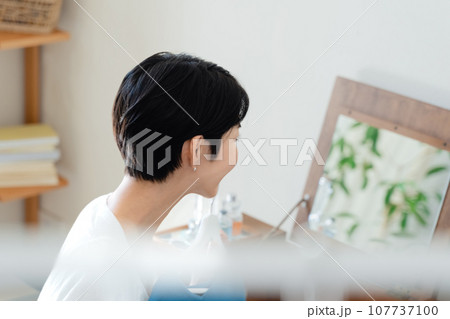 部屋で外出準備をする女性 107737100