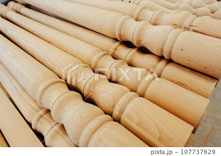 Wooden baluster stacked on the floor in woodwork workshop 107737629