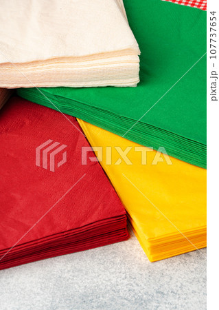 Stacks of colorful paper napkins on gray background Stacks of colorful paper napkins on gray background 107737654