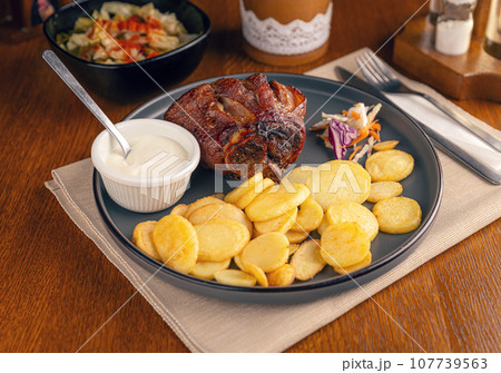 Roasted pork knuckle with potatoes 107739563