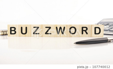 Buzzword - word word assembled from wooden cubes next to a calculator, pen and notepad Buzzword - word word assembled from wooden cubes next to a calculator, pen and notepad 107740012