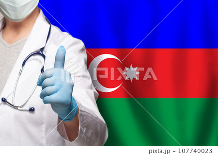 Azerbaijani doctor's hand showing thumb up positive gesture on flag of Azerbaijan background Azerbaijani doctor's hand showing thumb up positive gesture on flag of Azerbaijan background 107740023