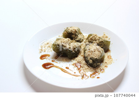 Matcha Warabi Mochi with Kinako powder and brown sugar syrup in white plate on white background, traditional Japanese dessert 107740044