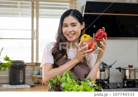 Woman holding vegetables for cooking meal. 107740533