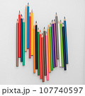 Colored pencils in the form of a wave on a white background 107740597