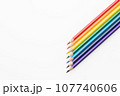 Rainbow color pencils in the form of an arrow from the right corner top view 107740606