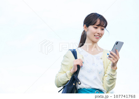 若い女性 青空 スマートフォン 若い女性 青空 スマートフォン 107741768