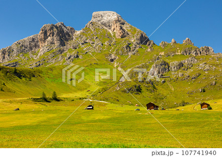 View of Peitlerkofel with wooden houses, green trees and grand mountain View of Peitlerkofel with wooden houses, green trees and grand mountain 107741940
